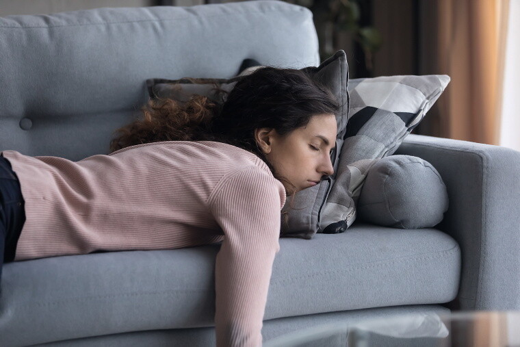 Frau schläft auf dem Sofa.
