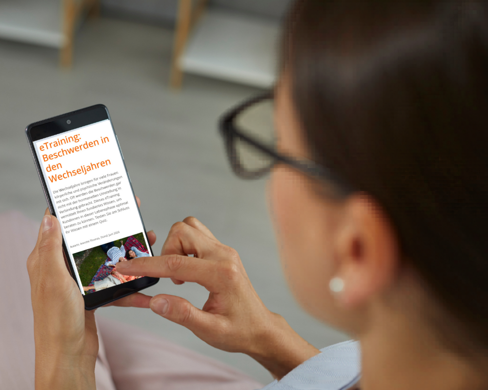 Frau schaut sich eTraining Wechseljahresbeschwerden auf dem Handy an.