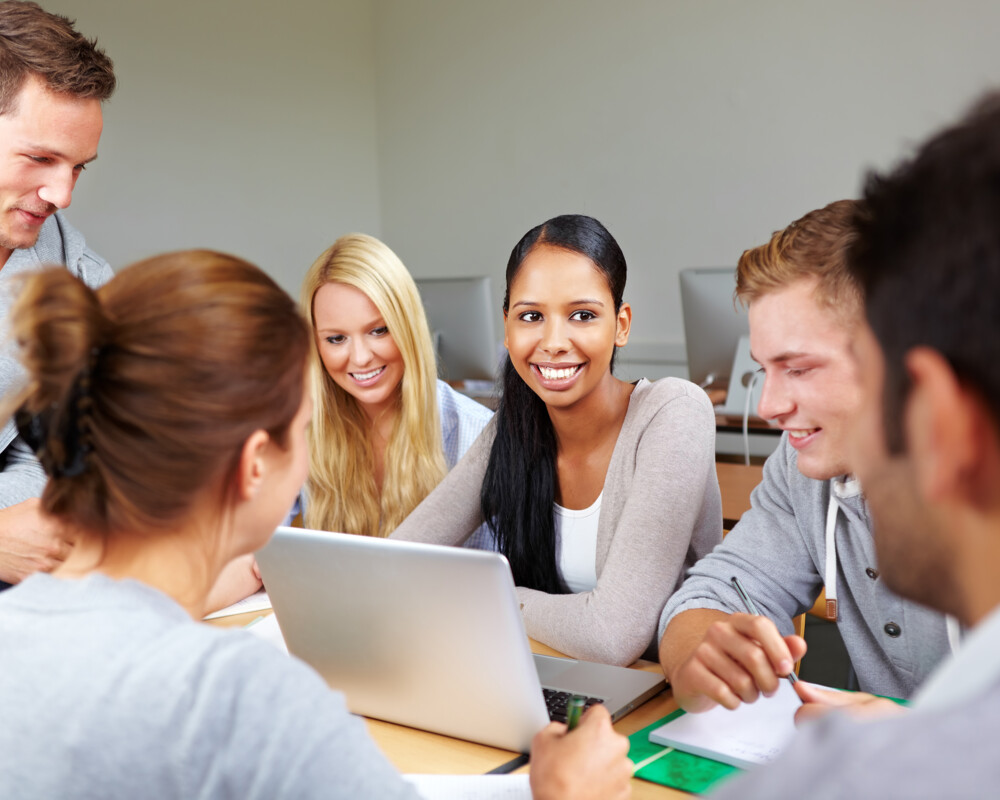 Junge Menschen um einen Laptop
