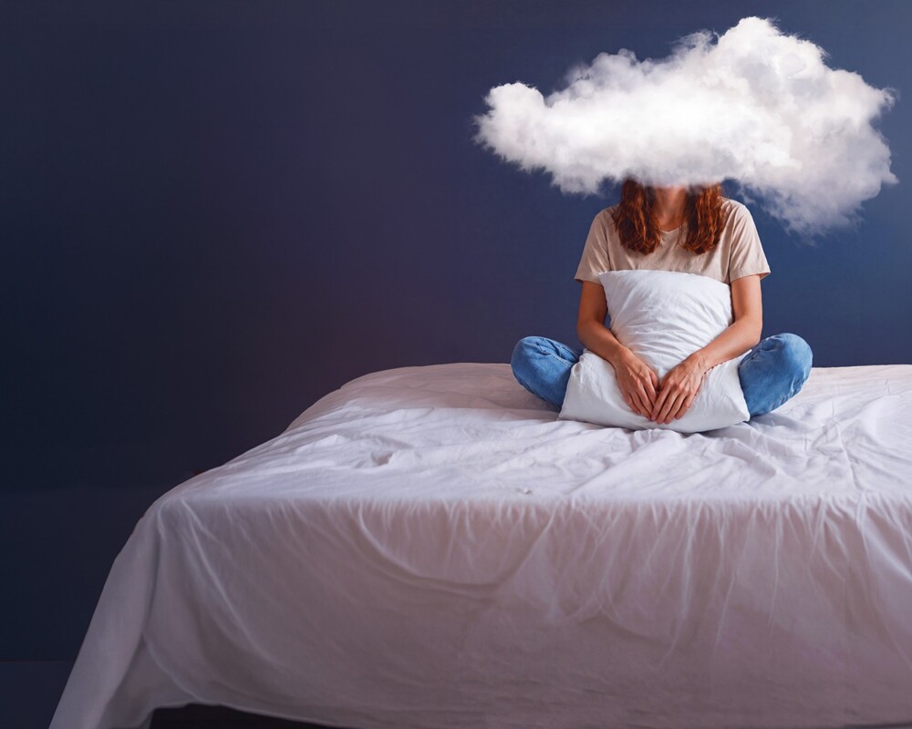 Frau im Bett mit Wolke vorm Kopf