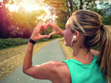 Joggerin formt Herz mit Händen.