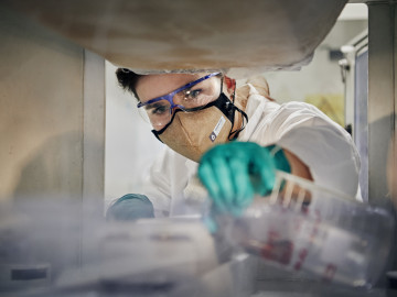 Wissenschaftlerin mit antiviraler Maske bei Laborarbeiten