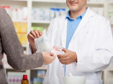 Kundin bezahlt Medikament in der Apotheke