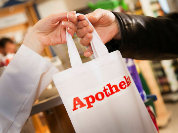 Tüte mit Apotheken A wird übergeben
