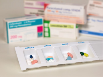Verschiedene Arzneimittelpackungen und Dosierhilfe
