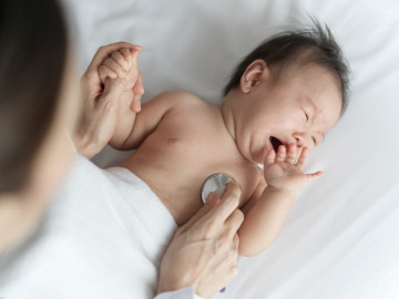 Arzt hört Herzschlag mit Stethoskop bei einem Baby ab