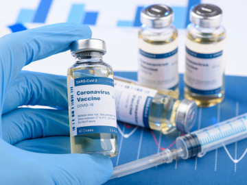 Impffläschchen mit Aufschrift Corona Vaccine und Spritze
