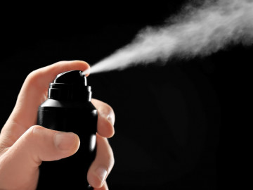 Männliche Hand sprüht Deo

