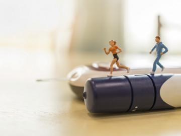Miniaturfiguren Mann und Frau laufen auf einem Insulinpen