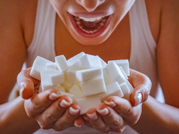 Frau hält einen Haufen Zuckerwürfel in ihren Händen