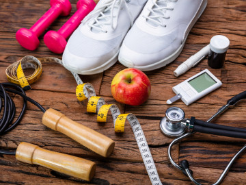 Sportausrüstung, Glukosemessgerät und Apfel