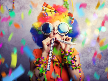 Frau zum Fasching mit Konfetti und Tröte 