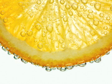 Zitronenscheibe mit perlender Flüssigkeit