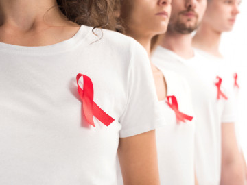 Gruppe von Menschen mit der roten „HIV-Schleife“
