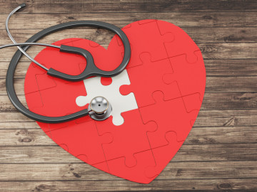 Rotes Herz aus Puzzleteilen mit Stethoskop


