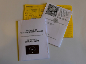 Gelber Impfausweise und Ausdruck mit QR-Code