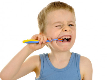 Junge verzieht Gesicht beim Zähneputzen

