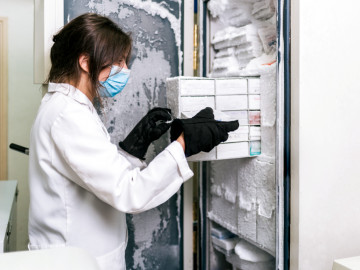 Frau am Laborkühlschrank mit Vials