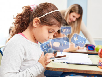 Junges Mädchen nutzt Smartphone in der Schule 