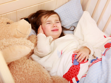 Mädchen mit Ohrenschmerzen im Bett