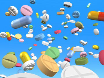 Durch die Luft fliegende bunte Kapseln und Tabletten.