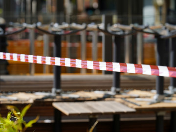 Rot-weißes Absperrband vor hochgestellten Tischen