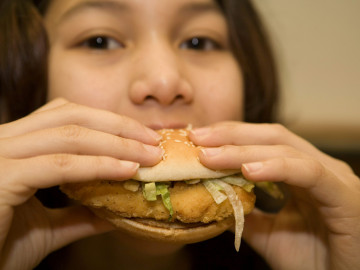 Mädchen verzehrt Fast Food