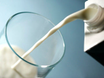 Milch aus einem Tetra Pak wird in ein Glas gegossen