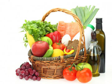 Korb mit den Zutaten der Mittelmeerkost: frisches Gemüse, Obst, Fisch, Olivenöl etc. 