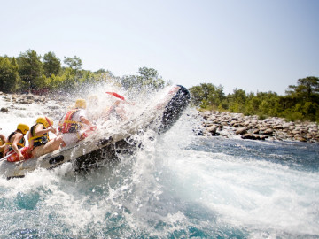 Menschen in einem Schlauchboot bei einer Fluss-Raftingtour.