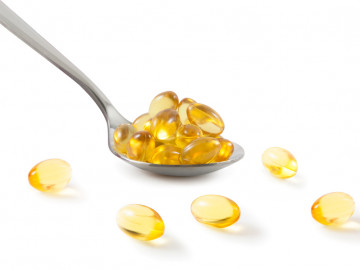 Omega-3-Kapseln auf einem Löffel