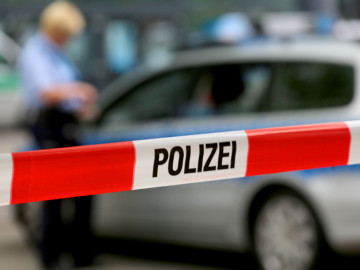 Ein Einsatzfahrzeug der Polizei steht hinter einer Polizeiabsperrung. 