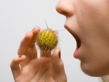 Frau hält stark vergrößerten Pollen in der Hand und muss gleich niesen