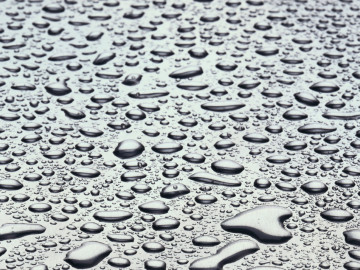Regentropfen auf grauer Oberfläche