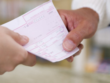 Kassenrezept, welches zwei Menschen in der Hand halten
