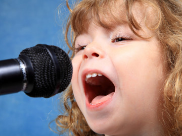 Mädchen singt in ein Mikrofon
