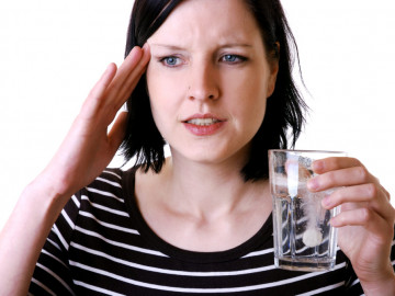 Frau mit Schmerzmittel im Glas