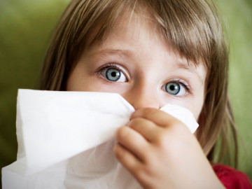 Mädchen putzt sich mit Papiertaschentuch die Nasen