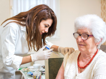 Seniorin erhält Impfung durch Medizinische Fachkraft