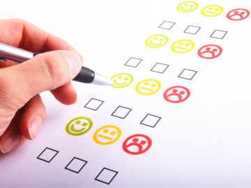 Per Hand auszufüllender Bewertungsbogen mit Smileys