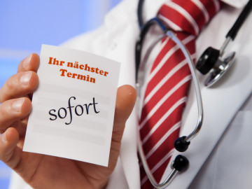 Arzt hält Post it mit der Aufschrift „Sofort“ in die Kamera
