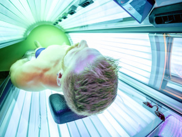 Mann liegt unter dem Solarium