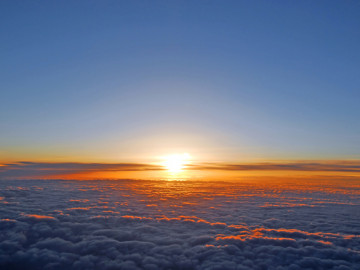 Blick aus dem Flugzeug: Die Sonne geht unter.