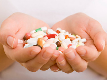 Bunte Tabletten und Kapseln in zwei Händen