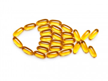 Vitamin D-Kapseln in Form eines Fisches gelegt. Laut einer statistischen Analyse eignet sich die Supplementierung von Vitamin D nicht zur Primärprävention von Krebs. 