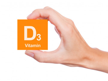 Hand hält orangefarbenes Quadrat mit Aufschrift D3 Vitamin