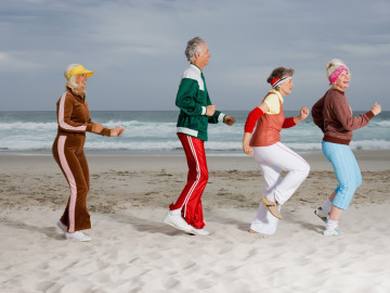 Drei sportliche Frauen und ein Mann am Strand 