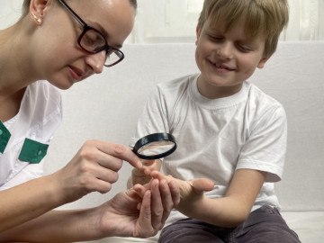 Ärztin untersucht die Hand eines Jungen