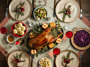 Weihnachtlich gedeckter Tisch mit Gans in der Mitte