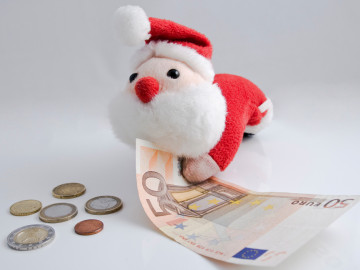 Weihnachtsmann aus Stoff hält 50-Euro-Schein